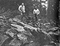 Glen Thomas and René Dahinden standing on the pile of rocks thrown up by the Sasquatch family (Bord 1982)